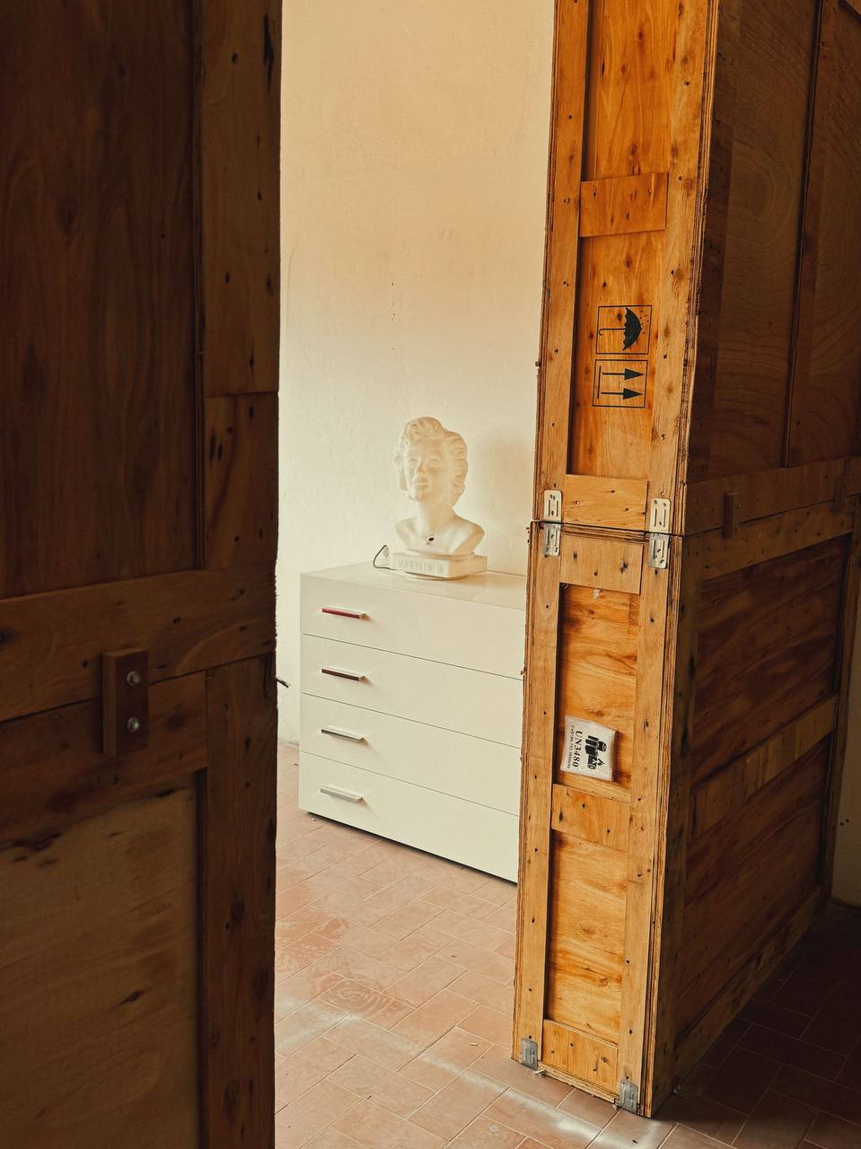 Scenografia interna con busto di marmo e cassa da trasporto